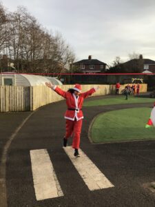 A student throws their arms in the air as they complete their Santa Dash,