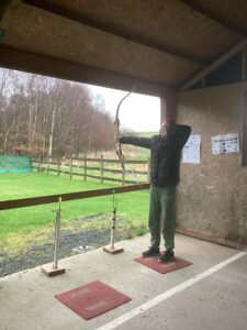 A student pulls back and takes aim as they enjoy some archery.