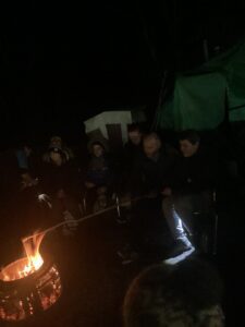 Staff and students enjoy some down time around the campfire whilst toasting marshmallows.