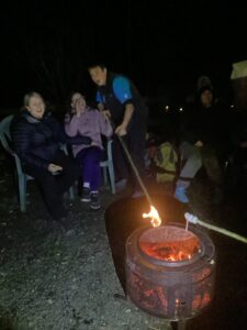 It's campfire time. A student is happy and smiling as they have a marshmallow toasted.