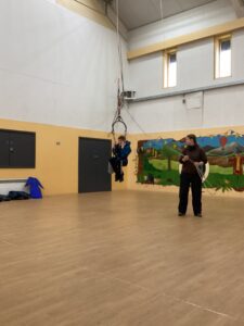 A student enjoys being in the swing and swinging around the sports hall.