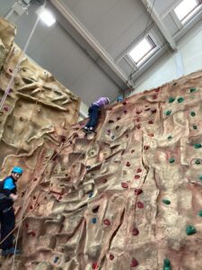 A student has made it to top of the climbing wall.