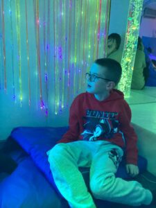 A student sits by the fibre optics and enjoys the array of colours.