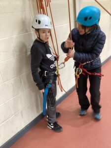 A student is getting ready to go on the climbing wall.